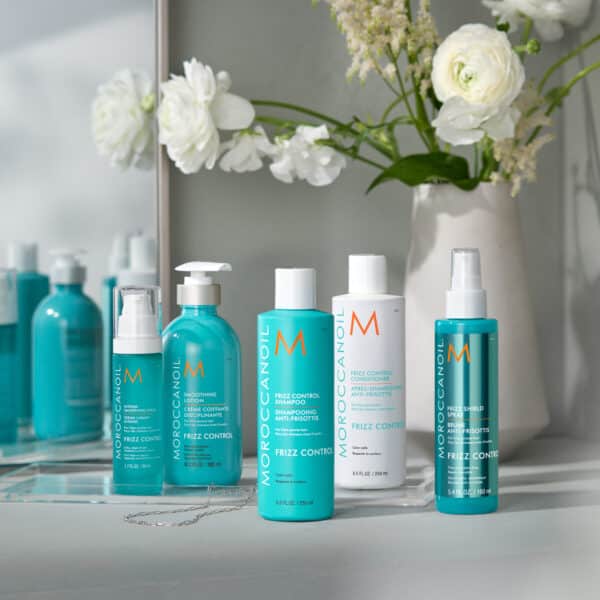 Colección completa Frizz Control de Moroccanoil frente a un espejo.
