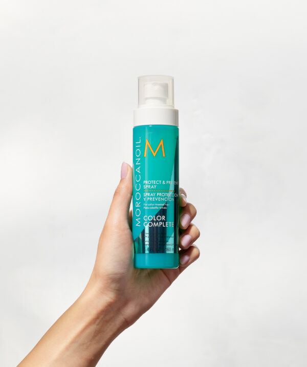 Mano sosteniendo el Spray Protect & Prevent Color Complete de Moroccanoil