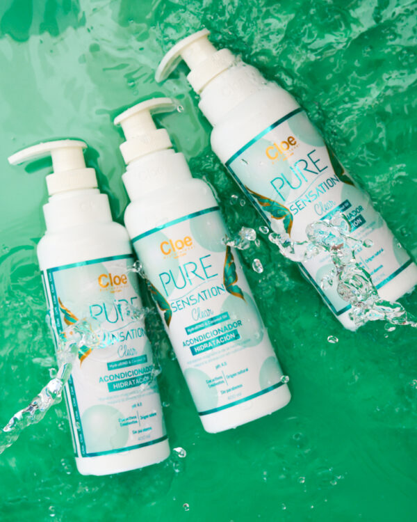 Varias botellas de acondicionador Pure Sensation Clear de Cloe Professional sobre un fondo acuático, resaltando su fórmula de limpieza profunda.