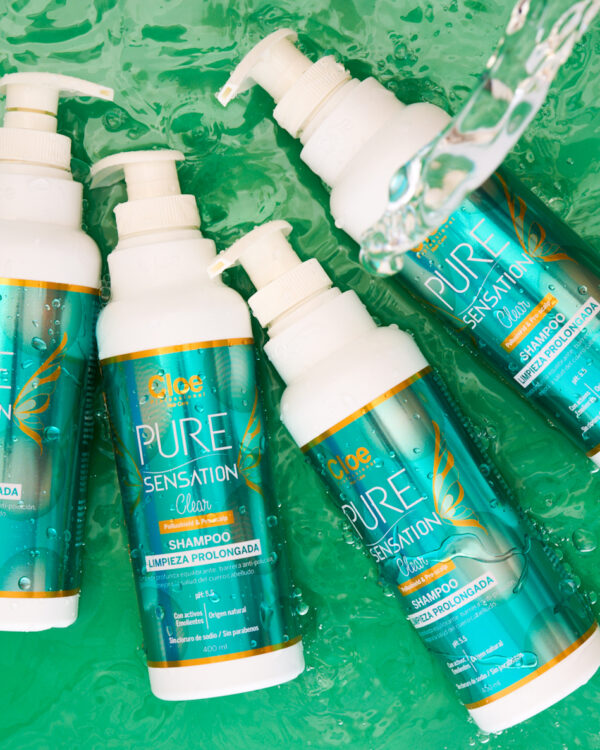 Varias botellas de shampoo Pure Sensation Clear de Cloe Professional sobre un fondo acuático, resaltando su fórmula de limpieza profunda.
