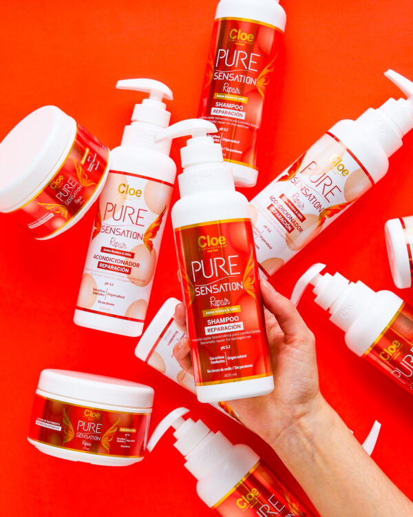 Shampoo y acondicionador Pure Sensation Repair de Cloe Professional sobre un fondo naranja, resaltando su fórmula restauradora.