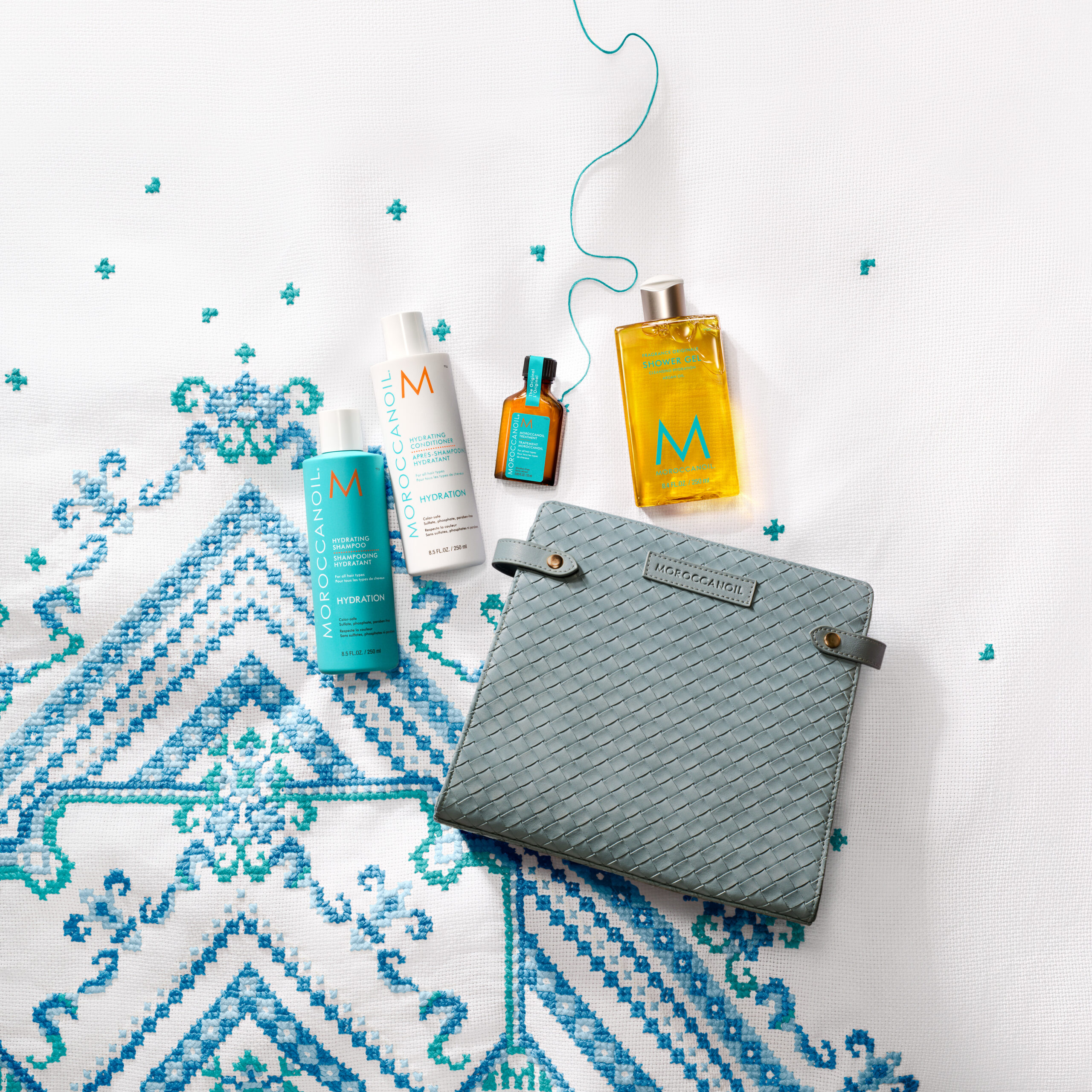 Kit de viaje Moroccanoil para el control del frizz, incluye shampoo, acondicionador, Aceite de Tratamiento y cosmetiquero azul.