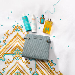 Kit de viaje Moroccanoil para reparación capilar con shampoo, acondicionador, Aceite de Tratamiento y un cosmetiquero azul.