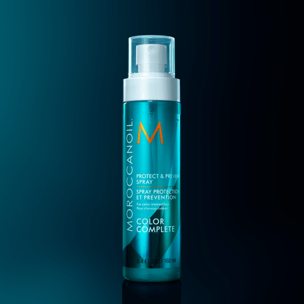 Spray Moroccanoil Protect & Prevent Color Complete sobre fondo oscuro