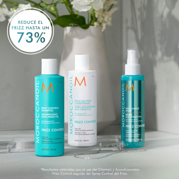 Kit de Shampoo, Acondicionador y Spray Frizz Control de Moroccanoil sobre una superficie gris.