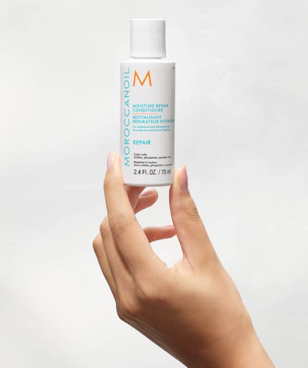 Acondicionador Moroccanoil Moisture Repair 70 ml sostenido en una mano