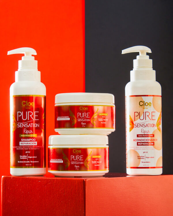 Kit de productos Cloe Pure Sensation Reparación compuesto por shampoo, dos mascarillas y acondicionador. Los envases están sobre fondo dividido en rojo y negro, con tonos blancos y rojos predominantes en las etiquetas.