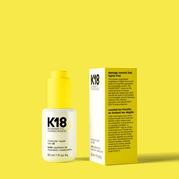 Botella de aceite capilar K18 Molecular Repair de 30 ml junto a su caja, ambos sobre fondo amarillo. La botella tiene dispensador amarillo y la caja muestra texto informativo en inglés y francés.