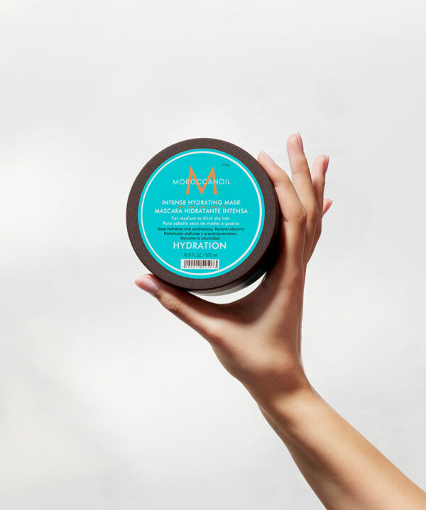 Envase de Máscara Hidratante Intensa Moroccanoil de 500ml sostenido en mano