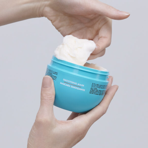 Mano extrayendo la Máscara Smooth Moroccanoil desde el envase