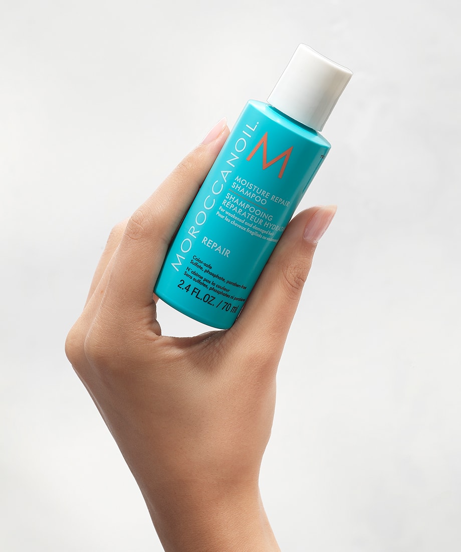 Shampoo Moroccanoil Moisture Repair 70 ml sostenido en una mano
