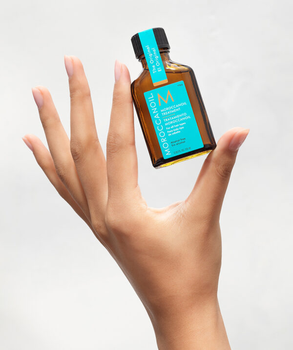 Tratamiento Moroccanoil Original de 25 ml sostenido en una mano