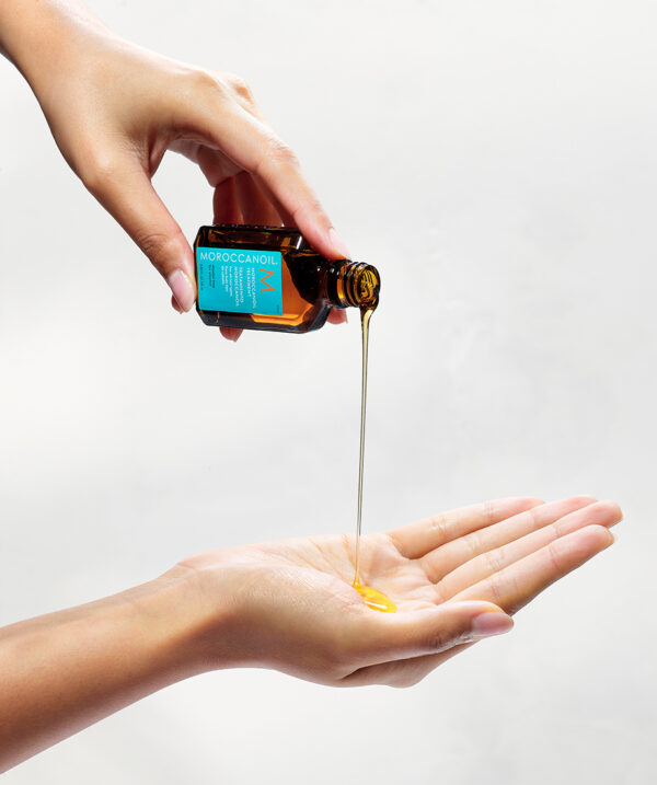 Aceite Moroccanoil Original vertiéndose desde botella de 25 ml