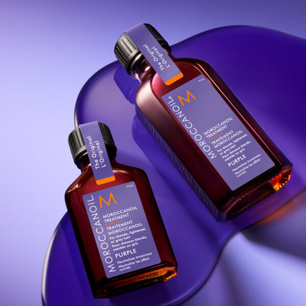 Dos frascos de Tratamiento Moroccanoil Purple sobre fondo violeta
